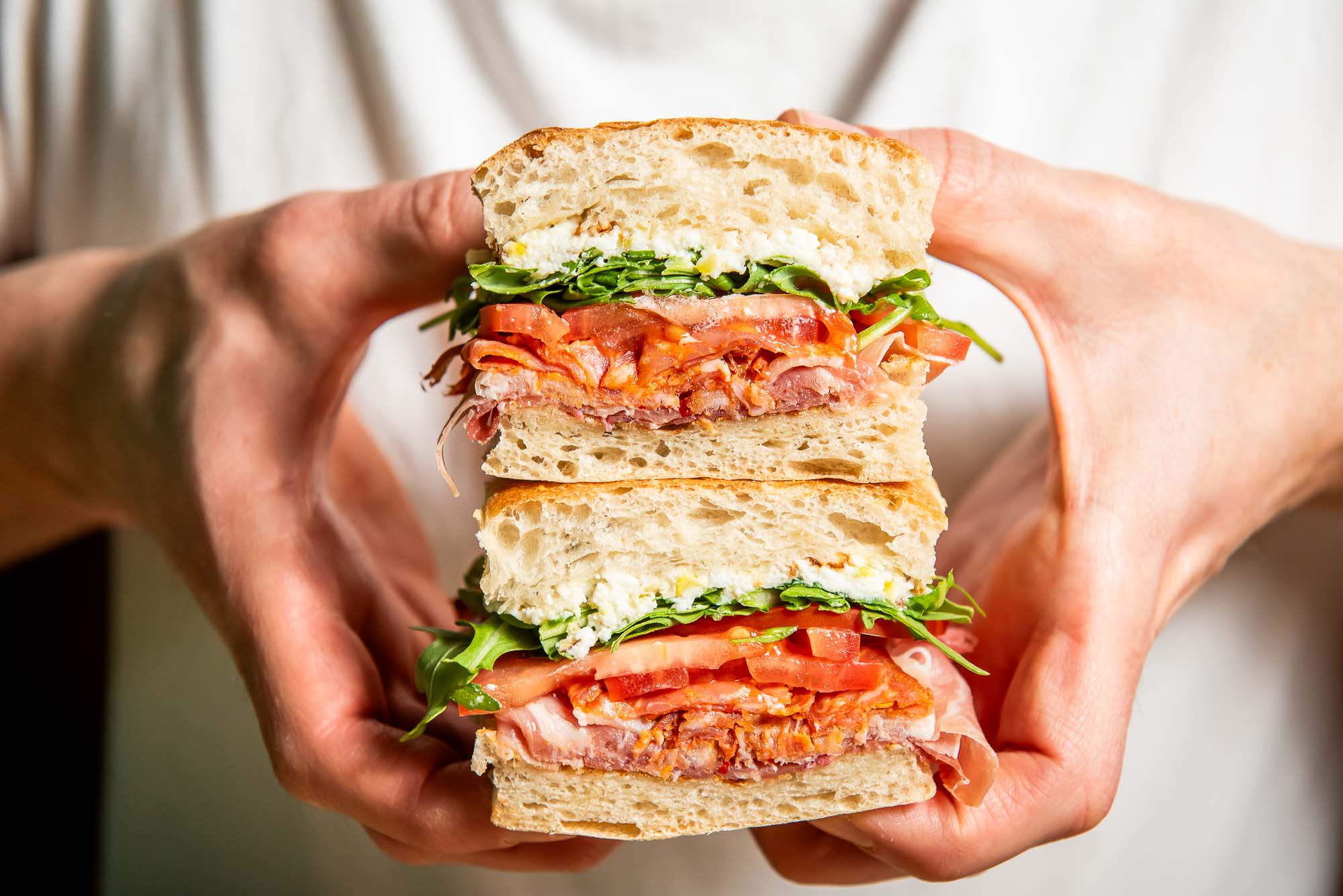 two hands stack sandwich halves